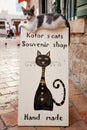 Sidewalk sign with lying cat in Kotor