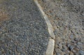 Sidewalk of volcanic stones of gray shiny color. For years, the surface of the paving is polished. Between the individual fraction