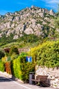 Sideway of a road with wooden bench, dead end road sign, shaped hedge on stone fence and private houses, hotels of a beautiful Royalty Free Stock Photo