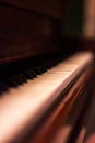 A sideways portrait of the white and black keys of a beautifful old wooden piano. Some of the keys are worn out or have fallen off Royalty Free Stock Photo