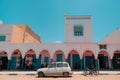Sidi Ifni, Morocco - colorful market exterior with blue doors and windows, pink walls, white arches.