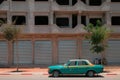 Mirleft, Morocco - old Mercedes Benz sedan Grand Taxi parked on street outside a building with closed steel doors. Royalty Free Stock Photo