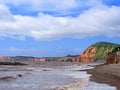 Sidmouth Beach, Devon, England. View towards Ladram Bay, red cliffs in late summer sun. On the Jurassic Coast.