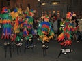 SIDMOUTH, DEVON, ENGLAND - AUGUST 10TH 2012: Children dressed up as colourful parrots and walking on stilts take part in the night