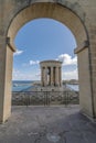 The Siege Bell War Memorial framed by an arch of the Lower Barrakka Gardens, Valletta, Malta Royalty Free Stock Photo