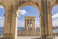 The Siege Bell War Memorial framed by an arch of the Lower Barrakka Gardens, Valletta, Malta Royalty Free Stock Photo