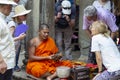 Siem Reap, Cambodia - 14 April 2018: Cambodian buddhist monk reading mantra for tourist in Angkor Wat temple.