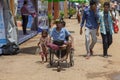 Siem Reap, Cambodia, 14 April 2018: Poor children and disabled beggar in chair on public market street.