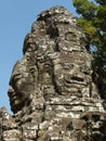 Portrait view of two female faces sculpted in stone in the Khmer temple complex of Angkor Royalty Free Stock Photo