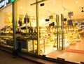 Beggar turns away from the camera, a homeless girl near the shop window of an expensive