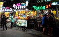 Kiosks selling ice cream and fruit cocktails, neon signs