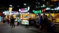 Kiosks selling ice cream and fruit cocktails, neon signs