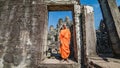 Monk by a stone gate at Angkor Wat site in Cambodia Royalty Free Stock Photo