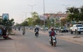 People on mopeds ride on a city street. Typical traffic in an Asian city. City life