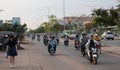 People on mopeds ride on a city street. Typical traffic in an Asian city. City life