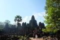 Tourists stroll and take pictures near the Bayon temple. Tourists see the sights of south