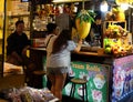 Young girl looks into the smartphone near the kiosk with street food