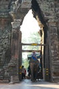 Tourists pass the south gate of Angkor Thom on an elephant