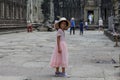 Siem Reap, Cambodia - 22 March 2018: Cambodian girl in Angkor Wat temple. Pretty girl in pink dress and native hat.