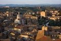 Siena cityscape. Picturesque aerial view of typical buildings red roofs from above at sunset from Torre del Mangia tower, Tuscany