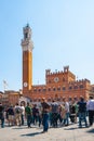 Old city sqaure or Palazzo Pubblico with crowd of tourists viewing historic Piazza Del Campo