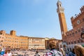 Old city sqaure or Palazzo Pubblico with crowd of tourists viewing historic Piazza Del Campo