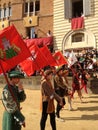 Tourists watching the colorful and fancy traditional costume parades at the horse race, Palio di Siena, held in medieval square Royalty Free Stock Photo