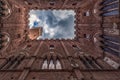 Siena Tower - Looking up towards Torre del Mangia Mangia tower from inside of Palazzo Publico inner courtyard in Siena, Tuscany