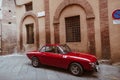 Red vintage car on the street of Siena city