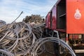 A civil protection truck next to a pile of wire rope coils in a junkyard