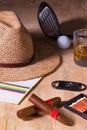 Siesta - cigar, straw hat,Scotch whiskey and golf driver on a wooden desk Royalty Free Stock Photo