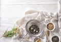 Sieves and bowls with dried chamomile and tea leaves on white table Royalty Free Stock Photo