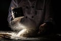 Sift flour by sieve, Horizontal shot of workplace with the flour for beating up dough. White flour flying into air. Food concept Royalty Free Stock Photo