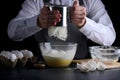 Sifting flour on dark background. recipe of pie or cake making concept Royalty Free Stock Photo