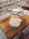Sifting flour through a pizza sieve