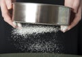 Sifting flour through a sieve closeup