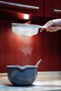 Sifting flour through a sieve into a plastic bowl Royalty Free Stock Photo