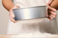 Sifting flour on wooden board