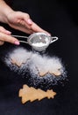 Sifting powdered sugar or flour on cookies. Homemade baking Royalty Free Stock Photo