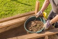 Sifting soil through a garden sieve to remove rubbish