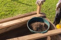 Sifting soil through a garden sieve to remove rubbish
