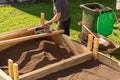 Sifting soil through a garden sieve to remove rubbish