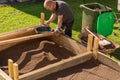 Sifting soil through a garden sieve to remove rubbish