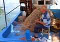 Unidentified Old Fisherman mending his nets Royalty Free Stock Photo