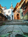 Colorful scene from the cobblestone streets of Sighisoara with the iconic Clock Tower in the