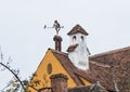 Weathervane in the form of a boy with a pipe and a bird on the roof of a dwelling house in the old city of Sighisoara in Romania