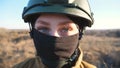 Sight of female ukrainian army soldier in helmet. Portrait of young woman in camouflage uniform confidently looking at