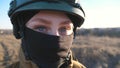 Sight of female ukrainian army soldier in helmet. Portrait of young woman in camouflage uniform confidently looking at