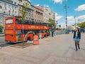 Sightseeing bus waiiting for tourists while people wandering on the street