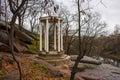 Sightseeing white rotunda or round gazebo on granite rocks and stones on background of the rainy sad autumn landscape. Photo to tr